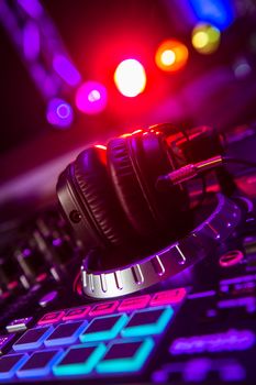 Dj mixer with headphones at a nightclub, music