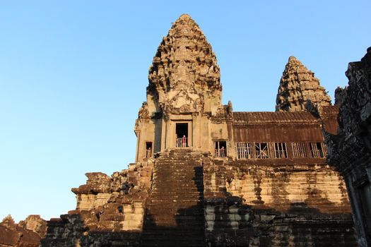 The setting sun rays on the walls of the ancient city of Angkor in Cambodia, near Siem Reap