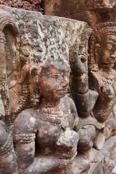 A beautiful ancient relief on the wall of a Cambodian Buddhist temple from Angkor complex, near the antique city of Siem Reap.