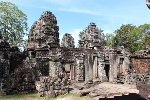 The ruins of a temple in the complex of Angkor, near the ancient city of Siem Reap. Black and gray stones, jungle around