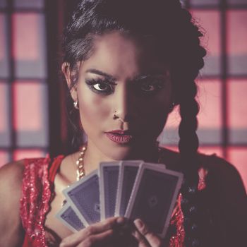 Happy and sexy female poker player with moody lighting.