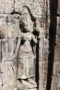 A beautiful ancient relief on the wall of a Cambodian Buddhist temple from Angkor complex, near the antique city of Siem Reap.