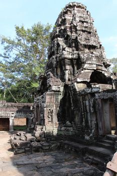 The ruins of a temple in the complex of Angkor, near the ancient city of Siem Reap. Black and gray stones, jungle around