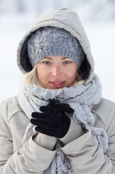 Portrait of cute casual young woman outdoor in snow in cold winter time.