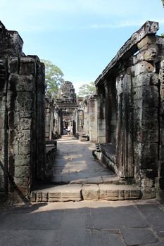 The ruins of a temple in the complex of Angkor, near the ancient city of Siem Reap. Black and gray stones, jungle around