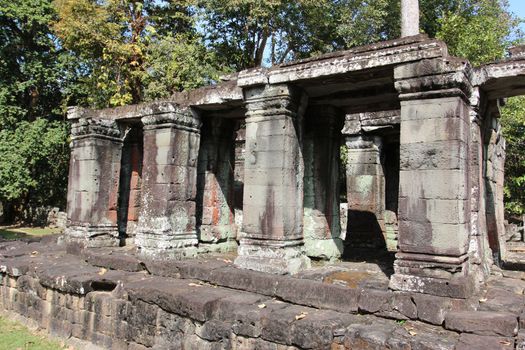 The ruins of a temple in the complex of Angkor, near the ancient city of Siem Reap. Black and gray stones, jungle around