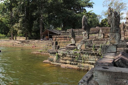 Pond near the ruins of the ancient temple of the temple in the middle of the jungle. Complex Angkor, Cambodia