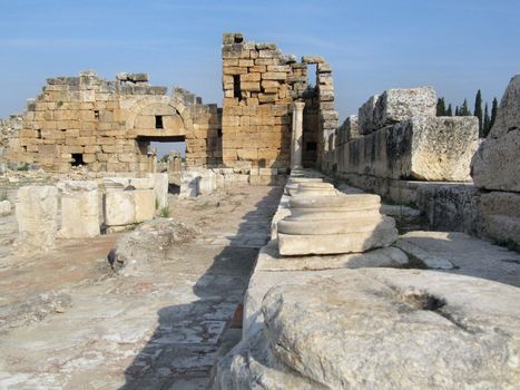 The ruins of an ancient Greek city in the background of hills and green cypresses. Turkey