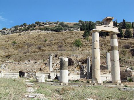 The ruins of an ancient Greek city in the background of hills and green cypresses. Turkey