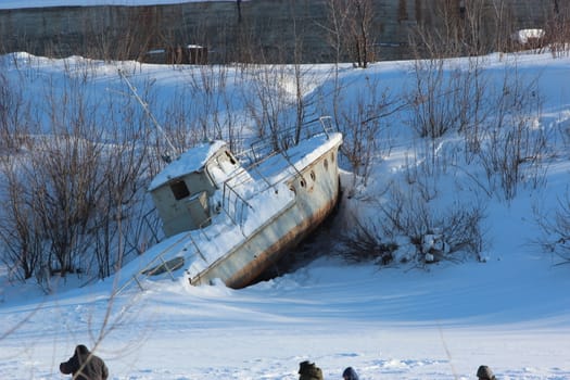 Broken boat on a winter city background