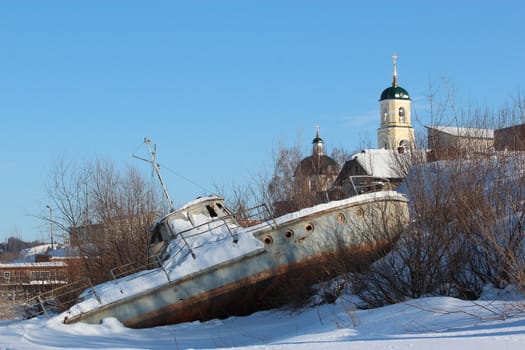 Broken boat on a winter city background
