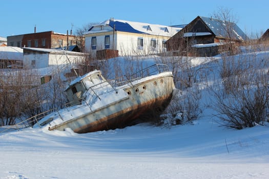 Broken boat on a winter city background