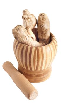 a pieces of ginger inside bamboo mortar