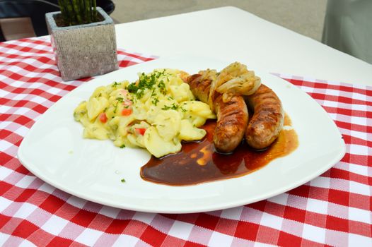 Grilled country sausages served with potatoes in salted and onion at Hofgut Sternen in the Black Forest in Germany