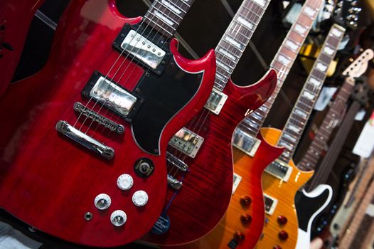 Many electric guitars hanging on wall in the shop, France