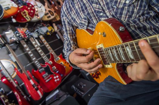 Young man playing the guitar in a shop, France