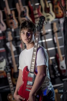 Young man playing the guitar in a shop, France