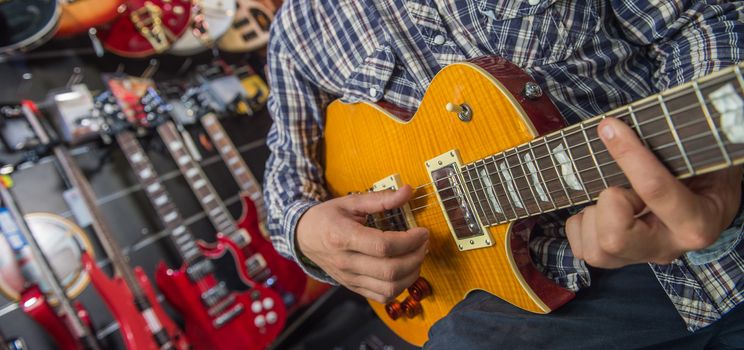 Young man playing the guitar in a shop, France