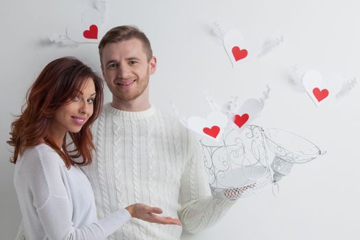 Young couple with winged hearts flying from the cage, Valentines day concept