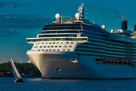 White giant brand new passenger ship moving in clear summer day