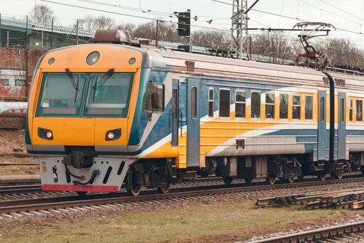 Yellow modern passenger electric train moving at the old terminal