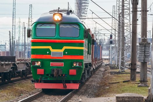 Green diesel cargo locomotive. Freight train in action
