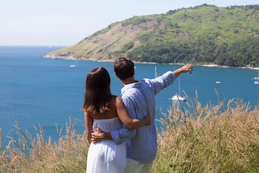 Young couple on vacation looking at sea together