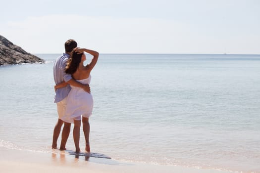 Young couple on vacation looking at sea together