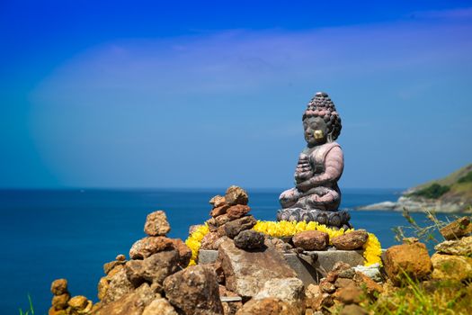 Traditional asian style buddha statue and flowers in Thailand. Sea landscape view