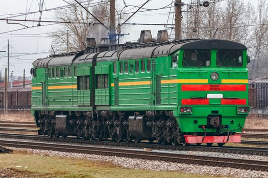 Green diesel cargo locomotive. Freight train in action