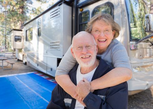 Senior Couple In Front of Their Beautiful RV At The Campground.