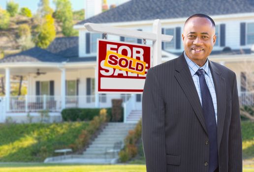 African American AgentIn Front of Beautiful Custom House and Sold For Sale Real Estate Sign.