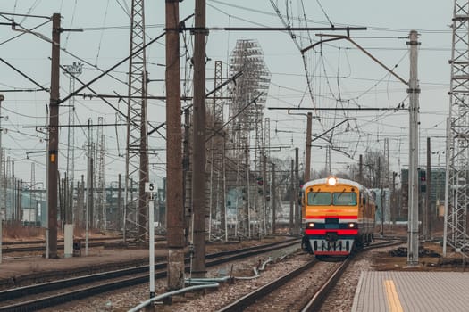 Old yellow passenger diesel train moving at the terminal