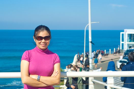 Beautiful young girl  looking at camera on city ocean coast bondi beach in Sydney,enjoying her holiday.