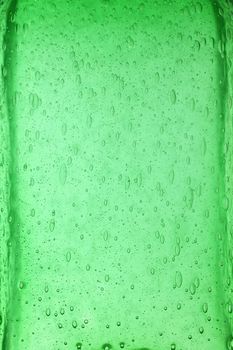 Background texture of solid transparent green color glass with pattern of air bubbles, close up