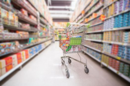 defocused of shelf and shopping cart in supermarket