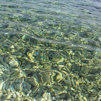 Beautiful background of crystal clear transparent sea water at sunny day