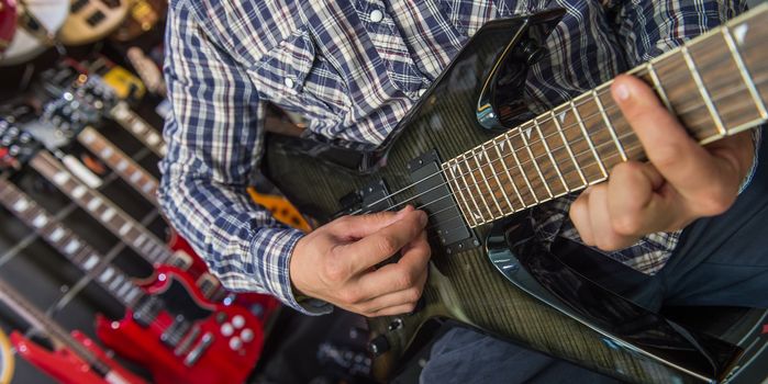 Young man playing the guitar in a shop, France