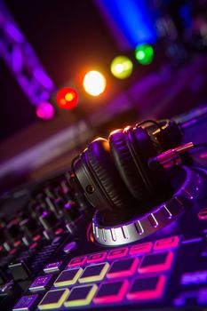 Dj mixer with headphones at a nightclub, music