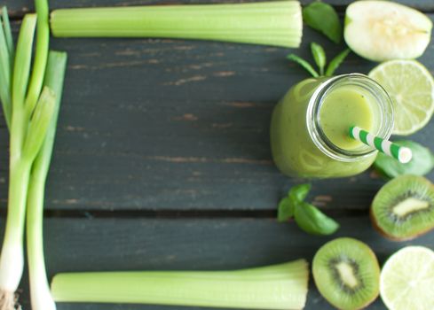 Blended smoothie with fresh ingredients on a wooden table with space for text 