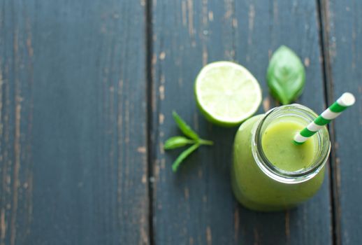 Fresh green smoothie on a wooden background with space