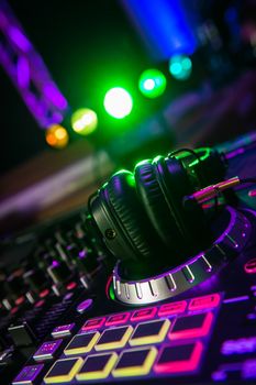 Dj mixer with headphones at a nightclub, music