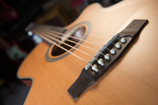 Macro shot down the fretboard of acoustic guitar with shallow depth of field, France