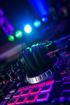 Dj mixer with headphones at a nightclub, music