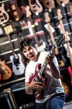 Young man playing the guitar in a shop, France