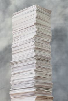 Tall stack of paper against a stormy sky