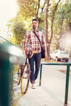 Young casual businessman going to work by bicycle.