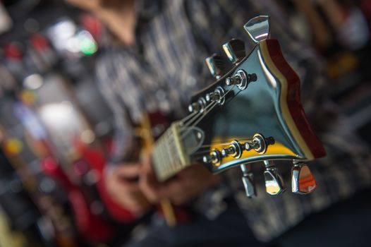 Young man playing the guitar in a shop, France