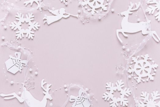 Christmas frame composed of white christmas decoration: snowflakes, deers, flying angel and gift boxes on pink background. Flat lay composition for websites, social media, business owners, magazines,  bloggers, artists etc.