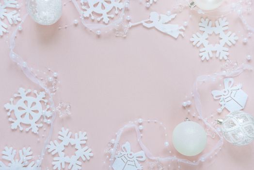 Christmas frame composed of white christmas decoration: snowflakes, balls, flying angel and gift boxes on pink background. Flat lay composition for websites, social media, business owners, magazines,  bloggers, artists etc.